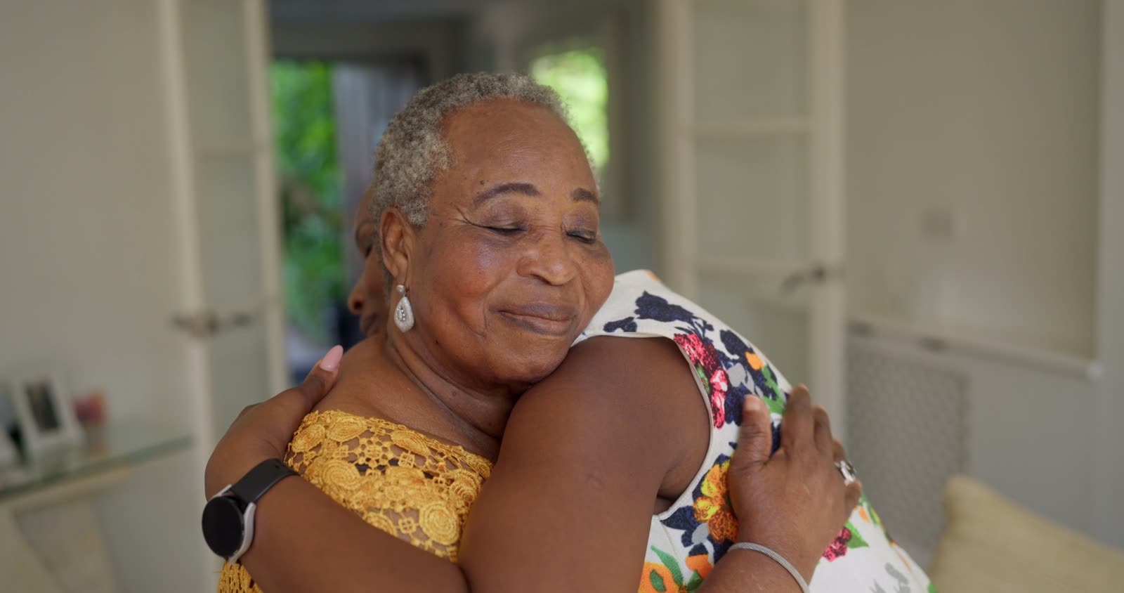 Two women hugging at home