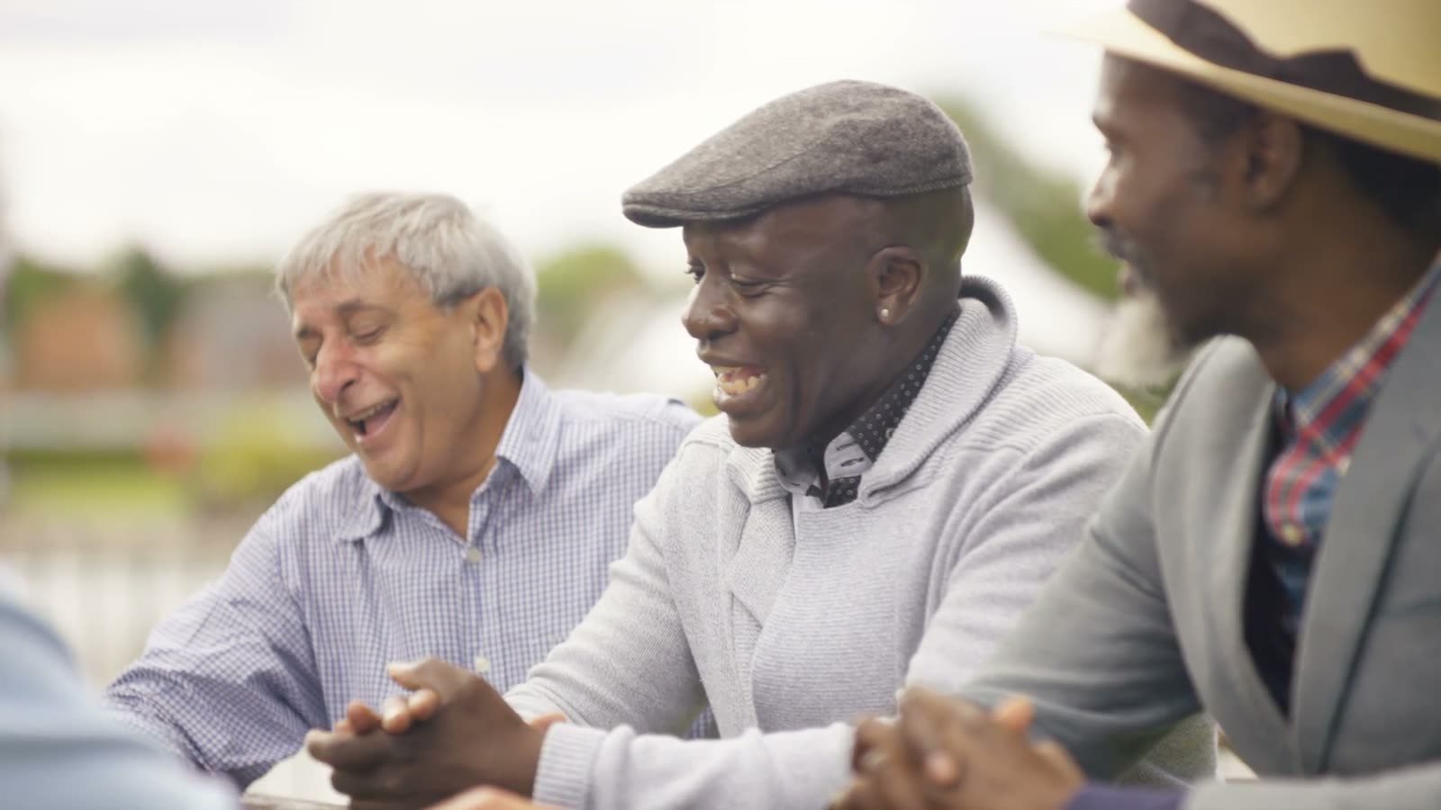 Three friends laughing together outdoors